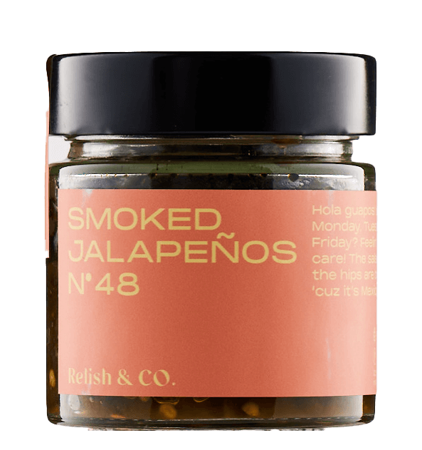 Close-up of Relish & Co. Smoked Jalapeño relish jar. Orange label, black lid, contents visible.