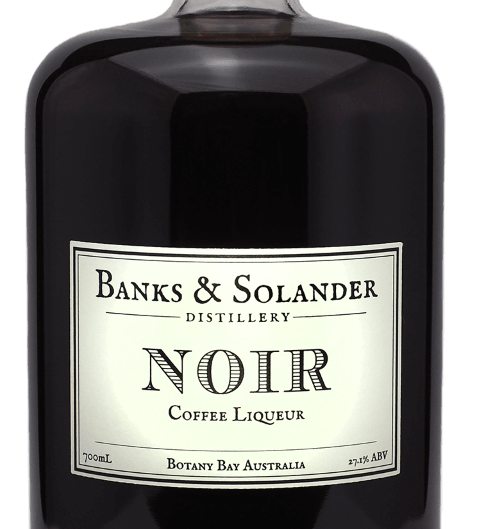 A bottle of Banks & Solander Noir Coffee Liqueur. The bottle is clear and shows the dark brown liqueur inside. The label reads "Noir Coffee Liqueur" and "Botany Bay Australia." The bottle is 700ml and has an alcohol content of 27.1%.