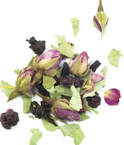 A scattering of dried rosebuds, green leaves, and dark berries, shot from above on a white background. The ingredients are textured and colourful, with a focus on the pink and purple hues.