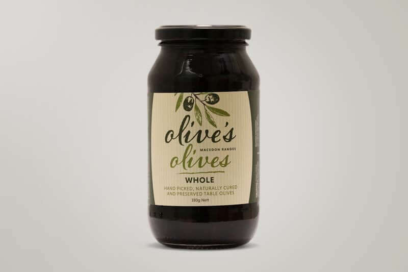 A glass jar filled with black olives. The label reads "Olive's Olives" and specifies they are whole, hand-picked, naturally cured, and preserved table olives from the Macedon Ranges.