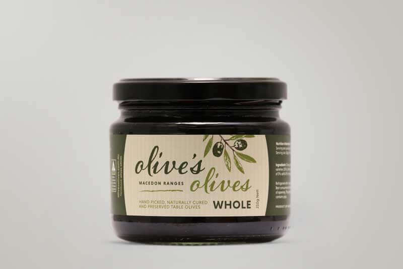 A glass jar of "Olive's Olives" from the Macedon Ranges. The jar is filled with whole, black olives. The label features a hand-drawn illustration of olives and emphasizes that the olives are hand-picked and naturally cured.