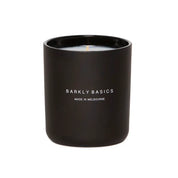 A black candle in a matte black glass jar. The jar is labeled "Barkly Basics" and "Made in Melbourne."