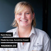 A portrait of Lisa from Hum Honey, based in the Sunshine Coast. She smiles warmly, wearing a branded Hum Honey shirt. Text overlay highlights MADEBOX.CO branding.