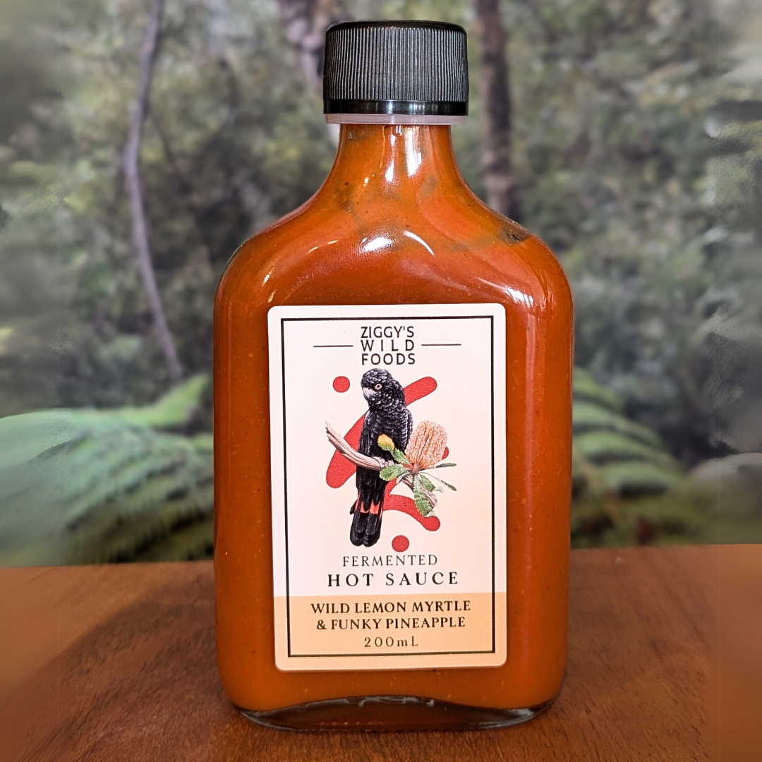 Ziggy's Wild Foods Fermented Hot Sauce, Wild Lemon Myrtle & Funky Pineapple, 200 mL. Label features a black bird on a branch with a flower. Perfect for adding a wild zing!