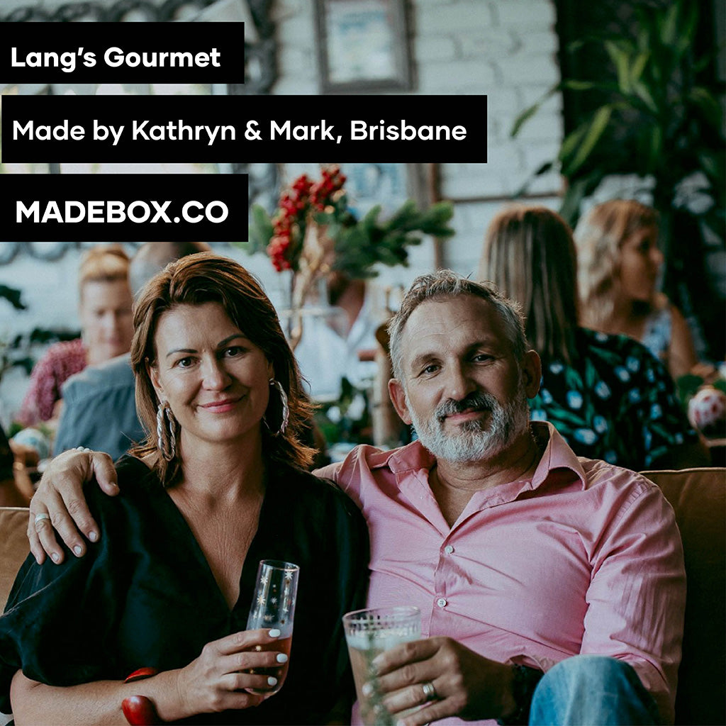 A warm portrait of Kathryn and Mark, creators of Lang’s Gourmet in Brisbane. They sit together, smiling, holding drinks. Text overlay highlights MADEBOX.CO branding.