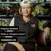 A woman with a hat sits in a chair, embodying elegance and tranquility in her posture. The text reads: Ferguson Seafood Made on Kangaroo Island